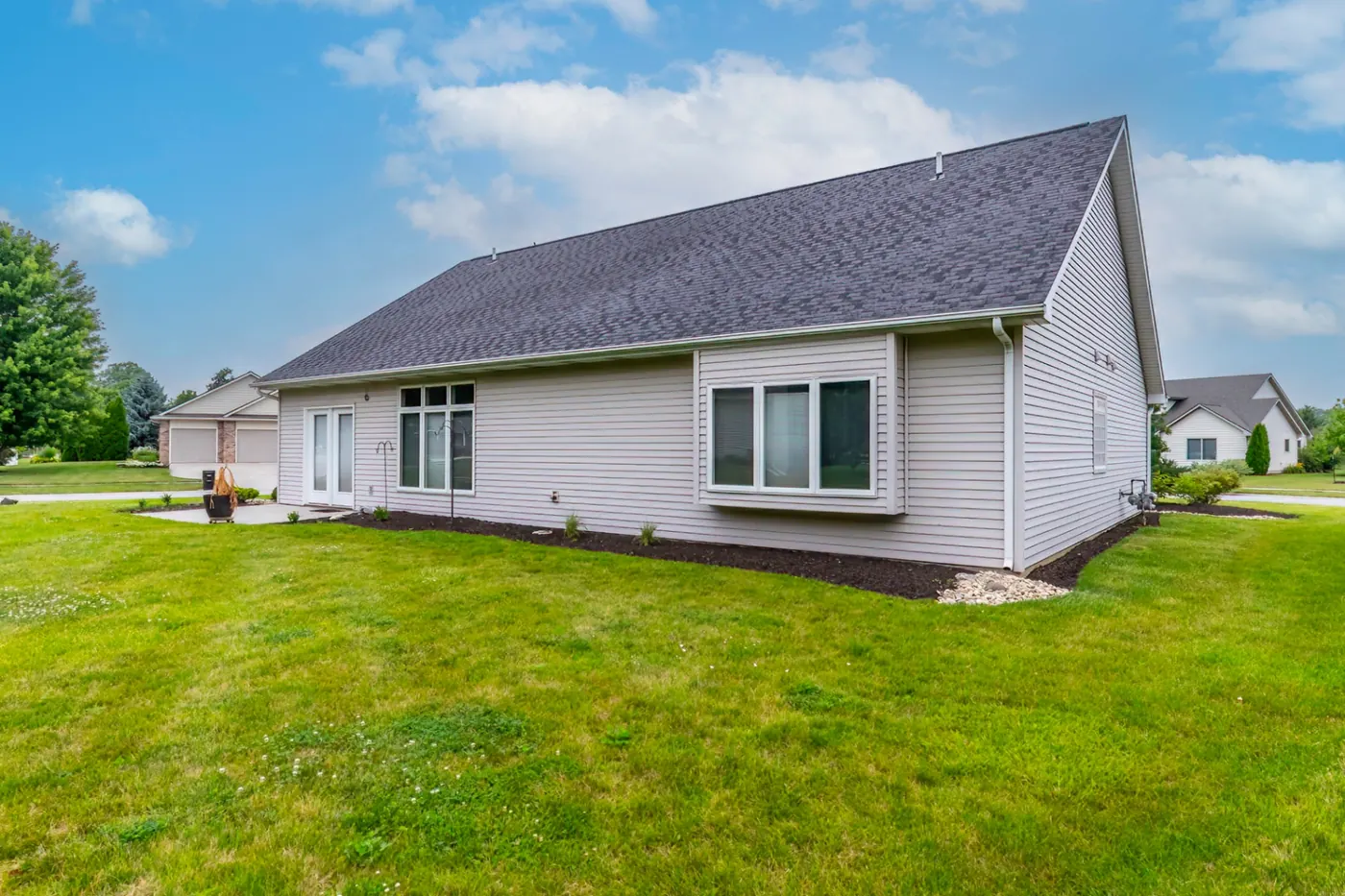 Side elevation of 1906 Kelleys Landing, Fort Wayne IN under blue sky, vinyl siding detail