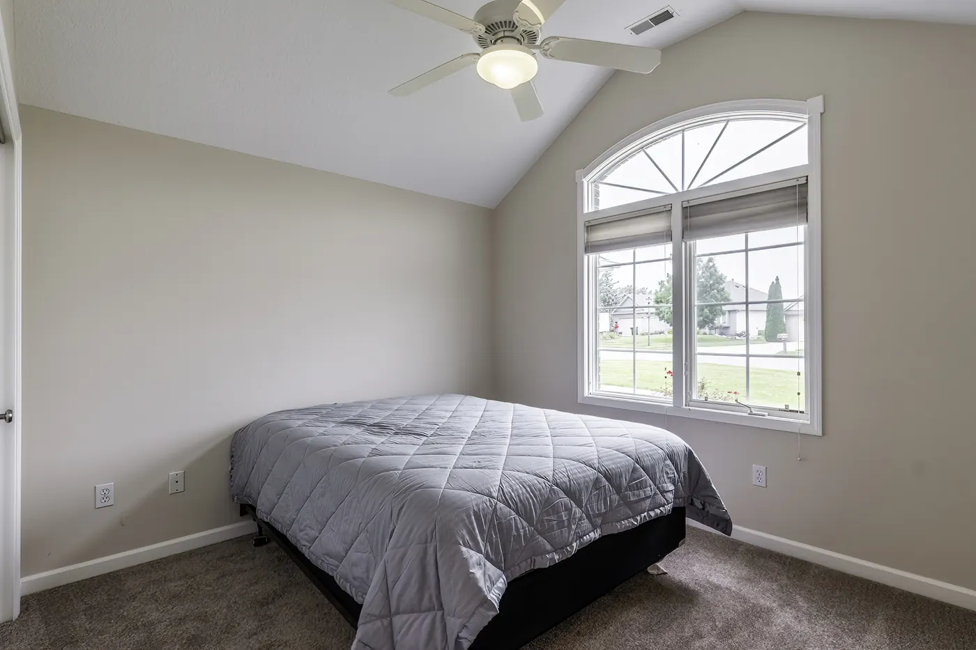 Bedroom at 1906 Kelleys Landing, Fort Wayne IN with arched window, vaulted ceiling and ceiling fan