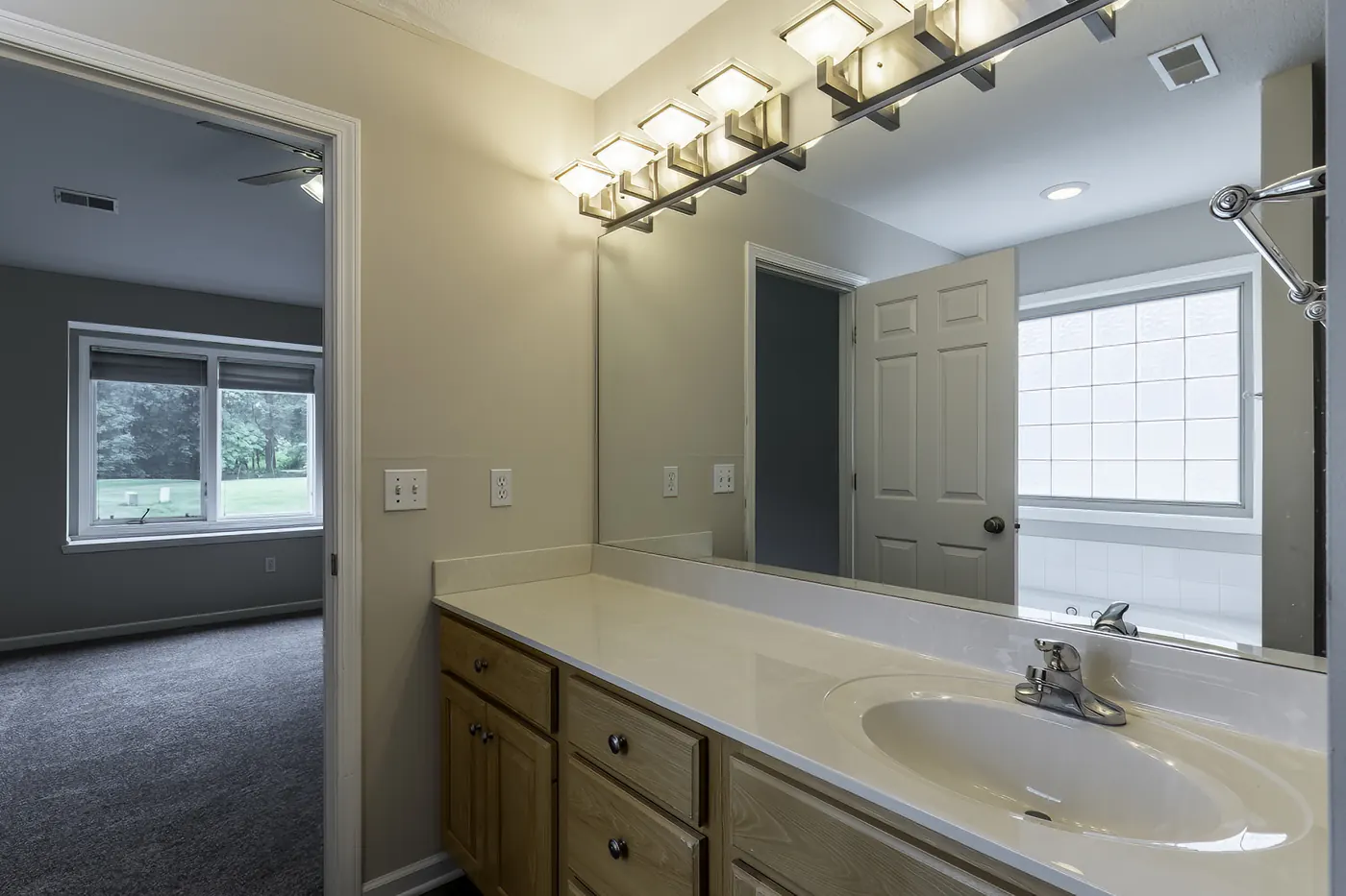 Long wood-cabinet vanity with large mirror in the primary bath at 1906 Kelleys Landing, Fort Wayne IN