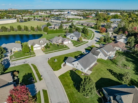 Aerial view of the home with the community pond