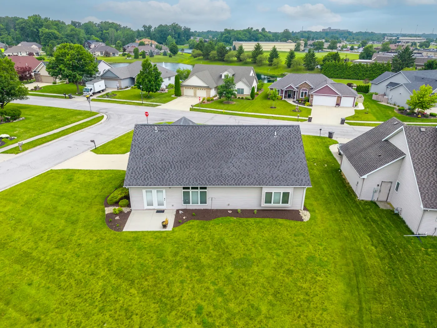 Rear elevation aerial of 1906 Kelleys Landing, Fort Wayne IN showing patio doors and backyard